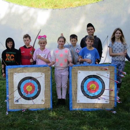 group of kids with archery target